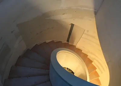 Spiraltrappe med trin i lyst træ under opbygning, set oppefra