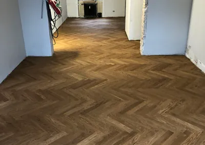 Nylagt sildebensparket i eg gennem flere rum i en lejlighed under renovering