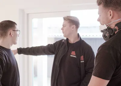 Tre medarbejdere fra Nemovo gennemgår opgaven i et lyst, tomt rum