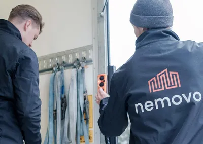 To flyttemænd fra Nemovo i ladet på en flyttebil med lastremme på væggen